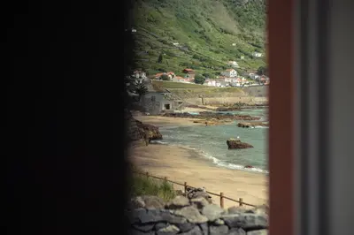 a view of a beach from a window at Vigia da Areia in São Lourenço