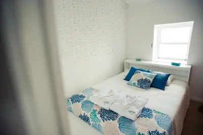 a bedroom with a bed with towels on it at Vigia da Areia in São Lourenço