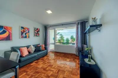 a living room with a couch and a large window at Apartamento Vista Oceano in Caniço