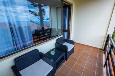 a balcony with two chairs and a window at Apartamento Vista Oceano in Caniço