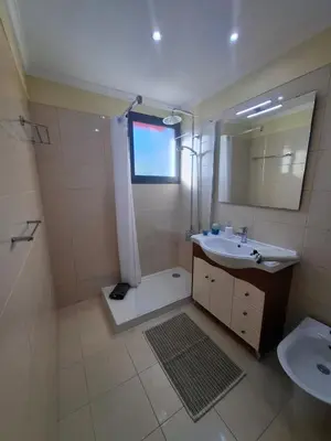 a bathroom with a shower and a sink and a mirror at Cozy and Bright Apartment in Machico