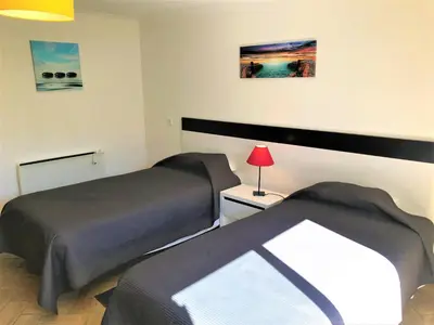 a bedroom with two beds and a table with a lamp at Casas da Vila in Luz