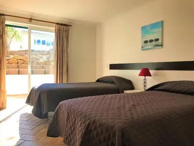 two beds in a hotel room with a window at Casas da Vila in Luz