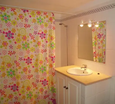 a bathroom with a sink and a shower curtain with flowers at Casas da Vila in Luz