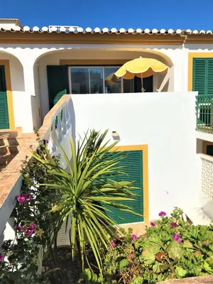 a white house with an umbrella on top of it at Casas da Vila in Luz
