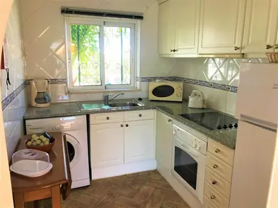 a kitchen with white cabinets and a sink and a dishwasher at Casas da Vila in Luz