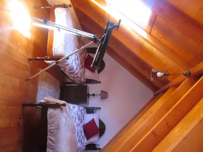 an attic room with wooden walls and stairs with towels at Casa Formiga in Fajã da Ovelha