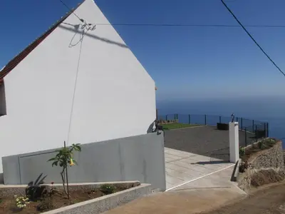 a white building with a view of the ocean at Casa Formiga in Fajã da Ovelha