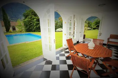 a porch with a table and chairs and a pool at Casa da Portada in São Vicente
