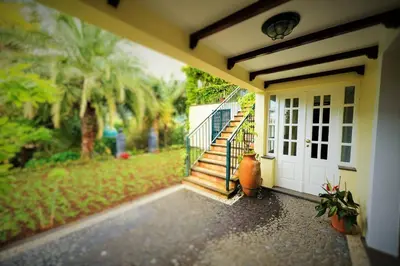 a porch of a house with a white door and stairs at Casa da Portada in São Vicente