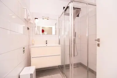 a white bathroom with a sink and a shower at Casa do Manuel in Santana