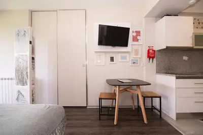 a small room with a table and a tv on a wall at Casa do Manuel in Santana