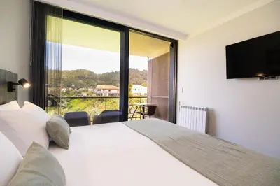 a bedroom with a large bed and a balcony at Casa do Manuel in Santana