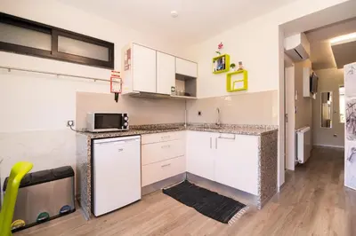 a kitchen with white cabinets and a microwave at Casa do Manuel in Santana