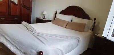 a bedroom with a large bed with white sheets and pillows at Morena house in Santa Cruz