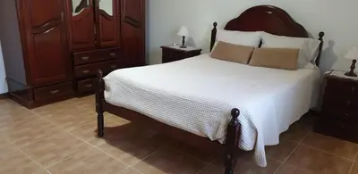a bedroom with a large bed with white sheets and pillows at Morena house in Santa Cruz