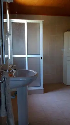 a bathroom with a sink and a glass door at Morena house in Santa Cruz