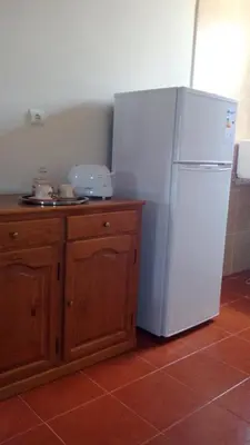a kitchen with a white refrigerator and a wooden cabinet at Morena house in Santa Cruz