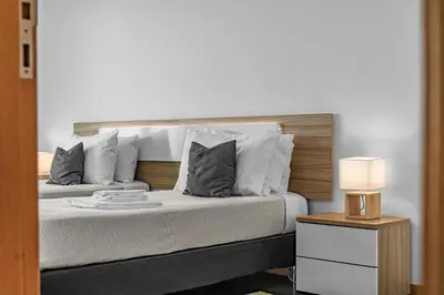 a bedroom with a large bed with white pillows at A&M House in Arco da Calheta