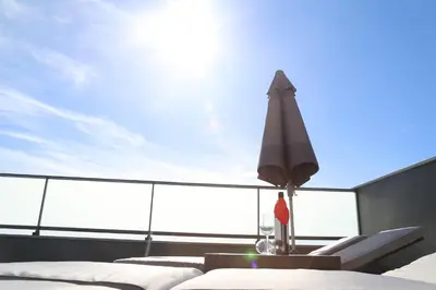 a table with a umbrella and chairs on a roof at A&M House in Arco da Calheta