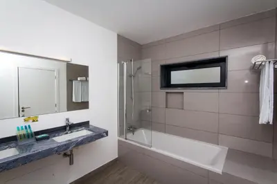 a bathroom with a tub and a sink and a mirror at Mareta Beach House - Boutique Residence in Sagres