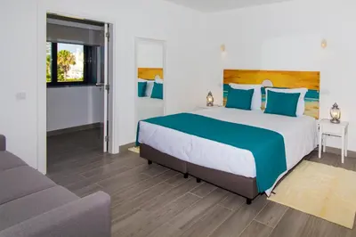 a bedroom with a large bed and a couch at Mareta Beach House - Boutique Residence in Sagres