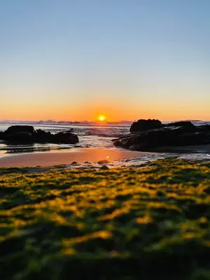 a sunset on a beach with rocks and the ocean at Mareta Beach House - Boutique Residence in Sagres