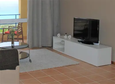 a living room with a flat screen tv on a white entertainment center at Apartamento Bela Vista in Porto Santo