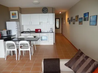 a kitchen and living room with a table and chairs at Apartamento Bela Vista in Porto Santo