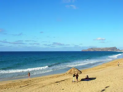 a group of people standing on a beach at Apartamento Bela Vista in Porto Santo