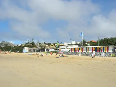 a group of people on a beach with a building at Apartamento Bela Vista in Porto Santo
