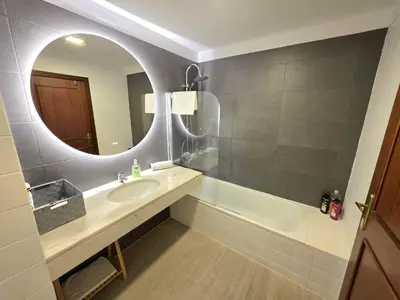 a bathroom with a sink and a mirror and a tub at Colinas do Lido III by Rentallido in Funchal