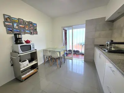 a kitchen and dining room with a table and a microwave at Colinas do Lido III by Rentallido in Funchal