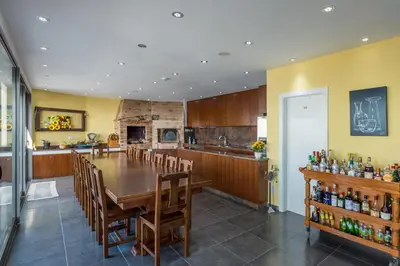a kitchen and dining room with a table and chairs at Villa São Lourenço in Fajã da Ovelha