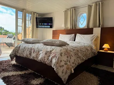 a bedroom with a bed with a tv on the wall at Villa Formosa in Funchal
