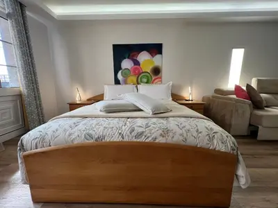 a bedroom with a large wooden bed with a couch at Villa Formosa in Funchal