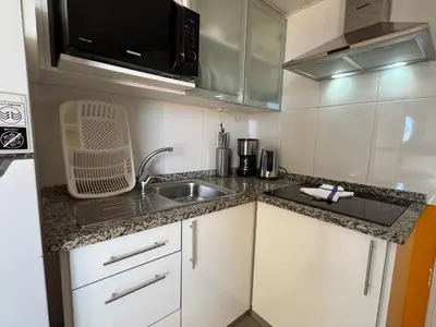 a small kitchen with a sink and a microwave at Villa Formosa in Funchal