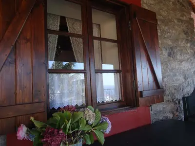 a window with a vase of flowers on a table at Casa da Rainha in Calheta