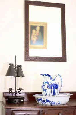 a picture frame above a table with a blue and white vase at Casa da Rainha in Calheta