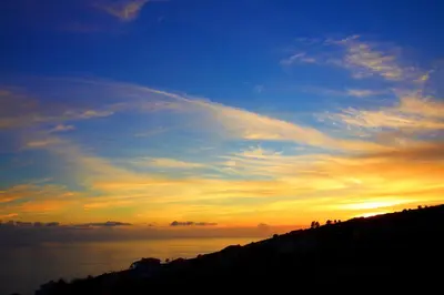 a sunset over a body of water with the sky at Casa da Rainha in Calheta