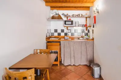 a small kitchen with a table and a sink at Carrapateiramar Guest House in Carrapateira