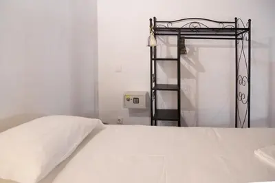 a bedroom with a white bed with a metal frame at Carrapateiramar Guest House in Carrapateira