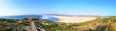 a view of a beach with a bridge and the ocean at Carrapateiramar Guest House in Carrapateira