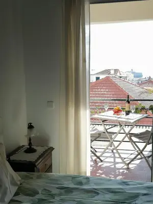 a bedroom with a view of a table and a balcony at Ladeira Centro in Funchal