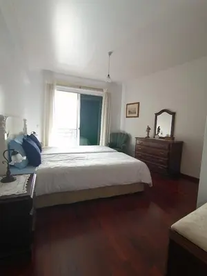 a bedroom with a bed and a mirror and a window at Ladeira Centro in Funchal