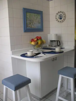 a kitchen counter with a bowl of fruit and two stools at Ladeira Centro in Funchal