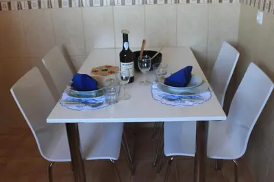 a white table with a bottle of wine and glasses at Maison Zita in Venda do Atalhinho