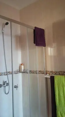 a bathroom with a shower with a purple towel at Maison Zita in Venda do Atalhinho