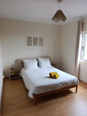 a bedroom with a bed with a yellow towel on it at Maison Zita in Venda do Atalhinho