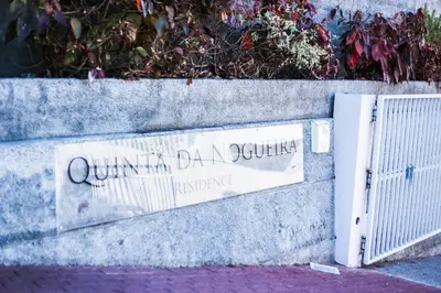 a sign on the side of a wall with a gate at Quinta da Nogueira in Funchal
